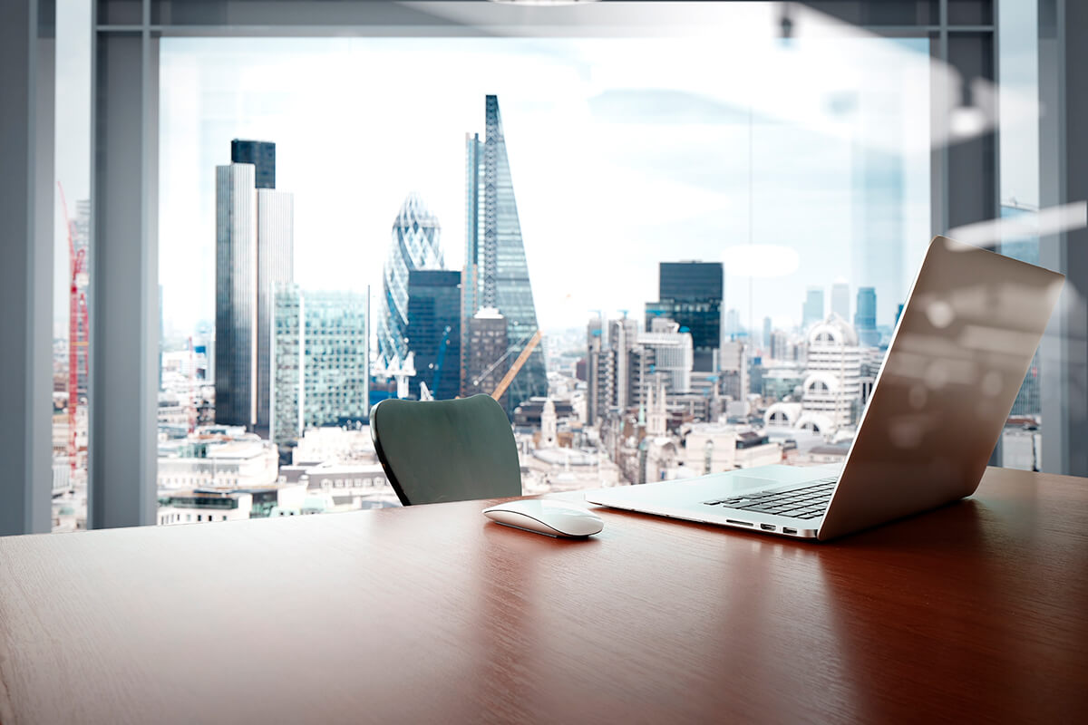 laptop in a conference room overlooking a city skyline 