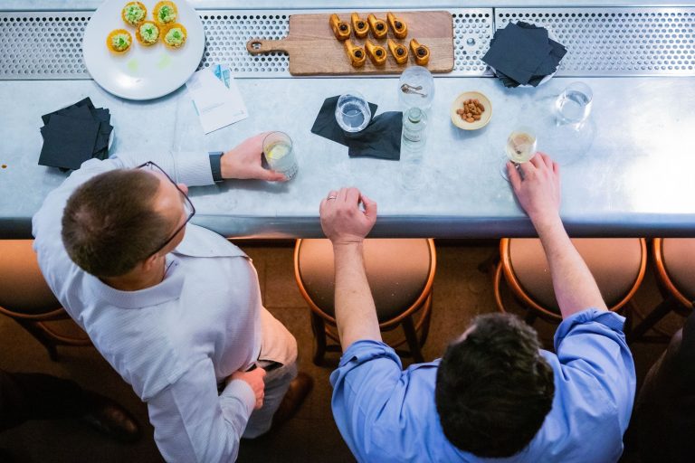 two coworkers chatting at an office kitchen table