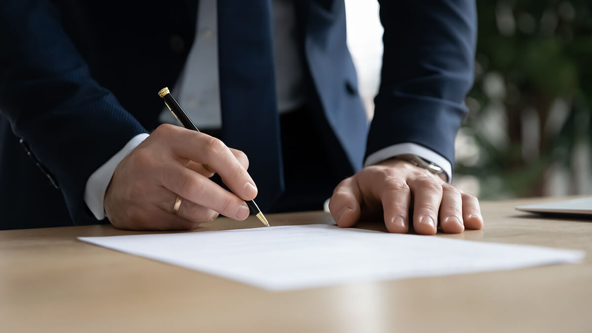 man in a suit signing a contract