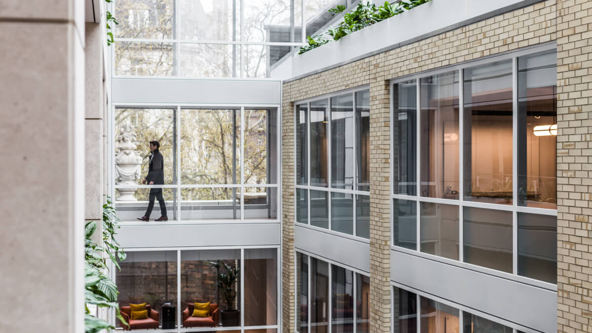 view of glass hallways in an office building with an employee